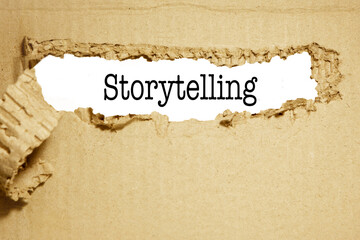 Storytelling is the best marketing words, appearing behind the torn cardboard. 