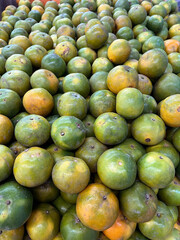 green and yellow oranges in the market