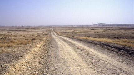 Naklejka premium A dusty rural road stretches through a wide expansive landscape