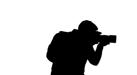 Silhouette of photographer aiming camera against a white background  