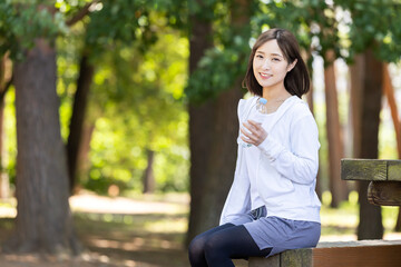 公園で水分補給する女性
