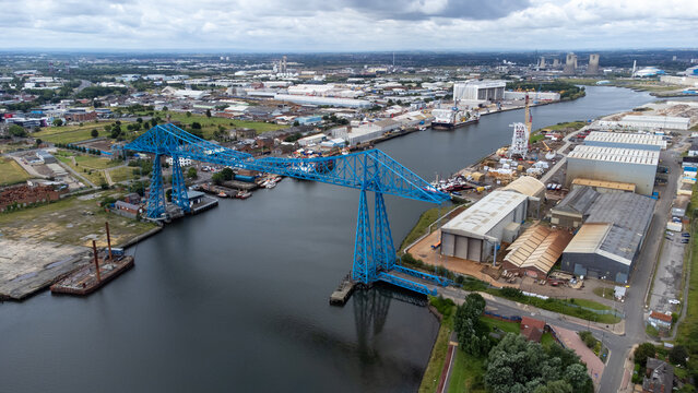 Aerial photograph of the historic Transporter Bridge spanning the River Tees in Middlesbrough, North East England. The image showcases the surrounding shipyards and industrial buildings