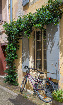 Fototapeta Charming street scene with vintage bicycle and green shutters in Arles, France. Peaceful southern atmosphere, summer light, urban details.