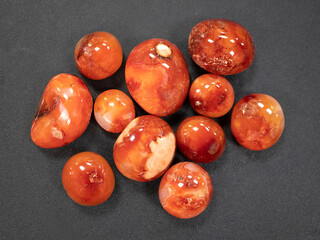 Radiant Carnelian stones on a deep dark surface. Concept of energy, vitality and protection