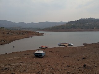Boats anchored near muddy lake shore
