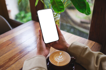 Mockup image of a woman holding mobile phone with blank screen