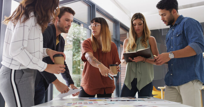 Creative, meeting and business people in office for planning, teamwork and ideas for book design. Publishing agency, discussion and workers with notes, color palette and editorial layout for print