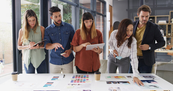 Business people, collaboration and tablet with planning, creative project and discussion. Group, employees and graphic designers in office, cooperation and tech with color for proposal or digital app