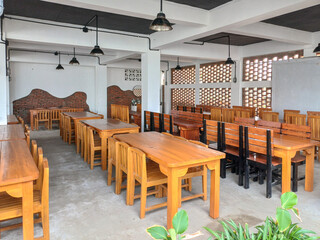 rows of wooden tables and chairs in a room with a comfortable classic feel