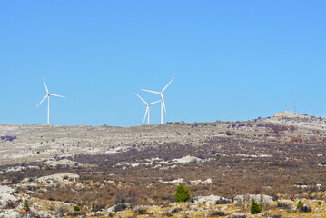 Exploring interesting places around Mostar: a mountain top with three wind turbines and ruins of an...