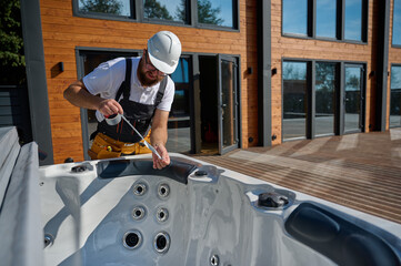 Plumber installing hot tub. Spa technician performing hot tub. Bathtub plumbing. Plumber fixing spa...