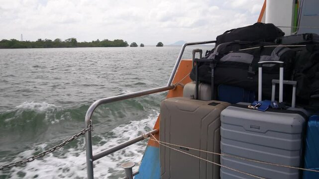 Ferry leaving Krabi Town port with luggage on the deck heading to Kho Phi Phi Island, Thailand