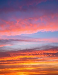 Fototapeta premium The sky is a vibrant orange, radiating warmth as the sun sets, casting a beautiful glow over the horizon and illuminating scattered clouds.