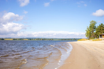 Serene beach landscape with gentle waves lapping against sandy shore under a clear blue sky