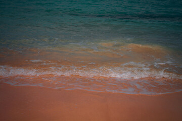Gentle sea waves washing over golden sand on a tropical beach. A calm and natural shoreline close-up, perfect for backgrounds and vacation themes.







