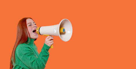Young woman enthusiastically uses a megaphone while promoting a cause against a vibrant orange backdrop