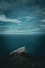 Panoramic view of the deep blue sea stretching to the horizon under a partly cloudy sky