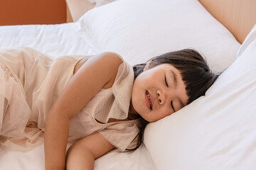 A Chinese little girl sleeping in bed