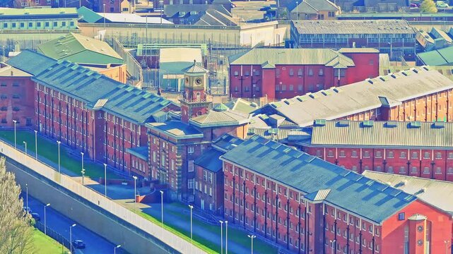 Aerial view of the red brick HM Prison in Wakefield, Yorkshire, England, showcasing its fortified walls and secure layout within the urban environment.
