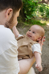 Father Holding Baby in Sunny Park