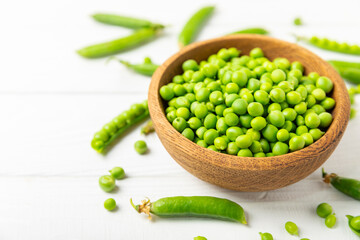 Fresh green pea pods with green peas on a wooden background. Sweet green peas. Green pea beans vegetables. Vegan. healthy vegetable. Copy space