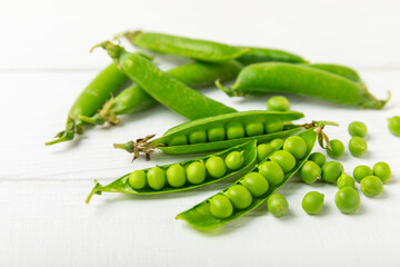 Fresh green pea pods with green peas on a wooden background. Sweet green peas. Green pea beans vegetables. Vegan. healthy vegetable. Copy space