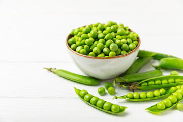 Fresh green pea pods with green peas on a wooden background. Sweet green peas. Green pea beans vegetables. Vegan. healthy vegetable. Copy space