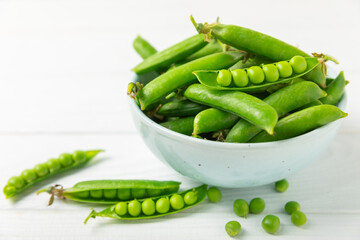 Fresh green pea pods with green peas on a wooden background. Sweet green peas. Green pea beans vegetables. Vegan. healthy vegetable. Copy space