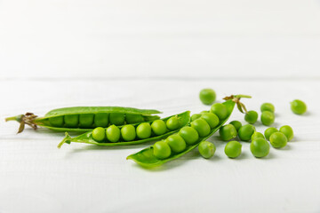 Fresh green pea pods with green peas on a wooden background. Sweet green peas. Green pea beans vegetables. Vegan. healthy vegetable. Copy space
