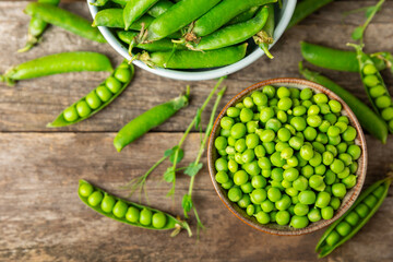 Fresh green pea pods with green peas on a wooden background. Sweet green peas. Green pea beans vegetables. Vegan. healthy vegetable. Copy space