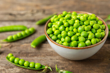 Fresh green pea pods with green peas on a wooden background. Sweet green peas. Green pea beans vegetables. Vegan. healthy vegetable. Copy space