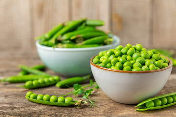 Fresh green pea pods with green peas on a wooden background. Sweet green peas. Green pea beans vegetables. Vegan. healthy vegetable. Copy space
