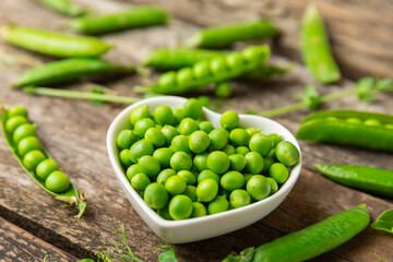Fresh green pea pods with green peas on a wooden background. Sweet green peas. Green pea beans vegetables. Vegan. healthy vegetable. Copy space