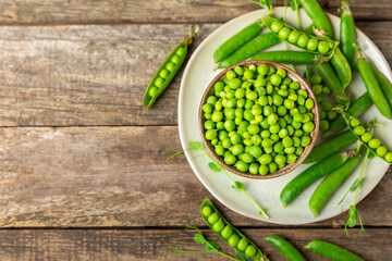 Fresh green pea pods with green peas on a wooden background. Sweet green peas. Green pea beans vegetables. Vegan. healthy vegetable. Copy space
