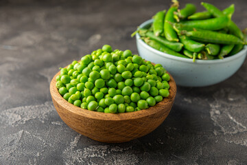 Fresh green pea pods with green peas on a wooden background. Sweet green peas. Green pea beans vegetables. Vegan. healthy vegetable. Copy space