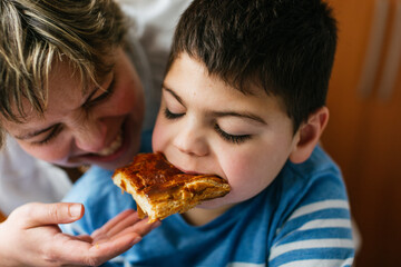 Mother sharing food with son with disability with microdeletion syndrome