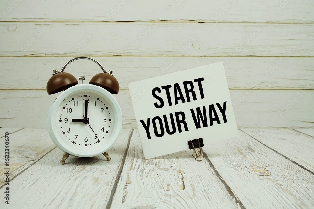 Poster start your way text on paper card with alarm clock on wooden background