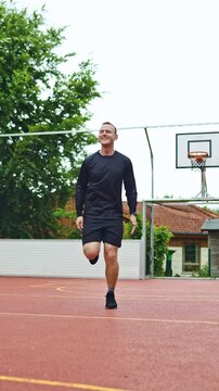 Young athletic man warming up before training outdoors. Man in sports shorts and raglan doing sports. Healthy lifestyle