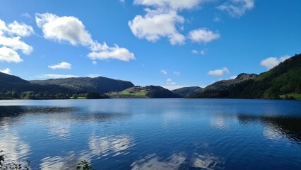 The blue lake merges with the sky, creating an infinite effect. The pure reflection of clouds and...