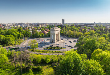 Arch of Triumph in Bucharest aerial photo. Travel to Bucharest Romania. Aerial view over this amazing historical landmark from Romania during a summer day with green parks landscape.