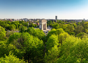 Arch of Triumph in Bucharest aerial photo. Travel to Bucharest Romania. Aerial view over this amazing historical landmark from Romania during a summer day with green parks landscape.