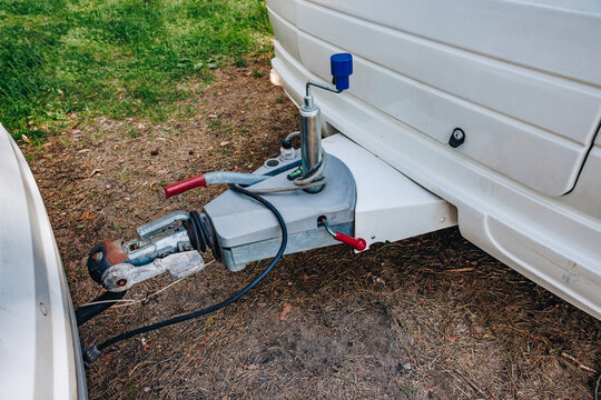Hooking up caravan to a car. Couple a trailer (i.s., hooked) into a ball-type tow hitch. Trailer coupling for caravans