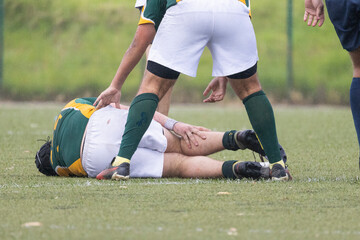 Rugby player suffering injury during match on field