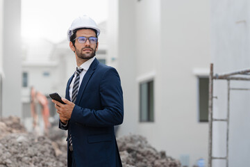 Portrait of handsome successful architect standing with arms crossed in building in construction process business man engineer.