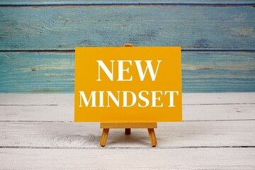 New Mindset text written on paper card on wooden background