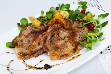 Close up of delicious fried pork chops with avocado and berries at plate
