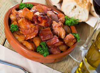 Delicious spanish dish Morro de cerdo, braised pig snout served in clay bowl with fresh parsley