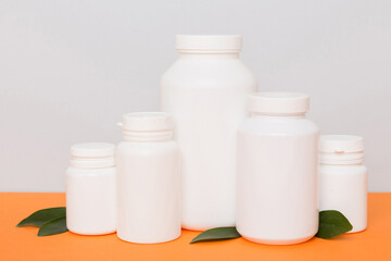 supplement pills with medicine bottle health care and medical top view. Vitamin tablets. Top view mockup bottle for pills and vitamins with green leaves, natural organic bio supplement, copy space