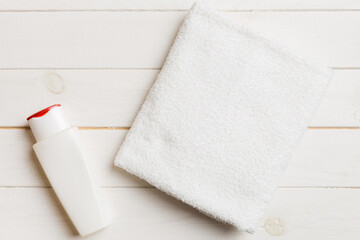 Cosmetic shampoo bottle mockup with towels on a colored table. Bathroom background, toilet accessories for hand and body care