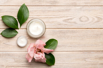 Composition with cosmetic products and beautiful roses on wooden background. Copy space, flat lay